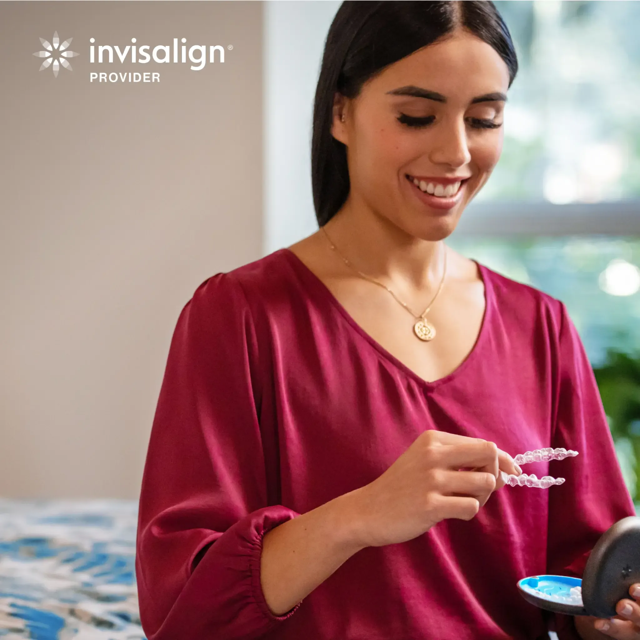 A woman holding Invisalign clear aligners