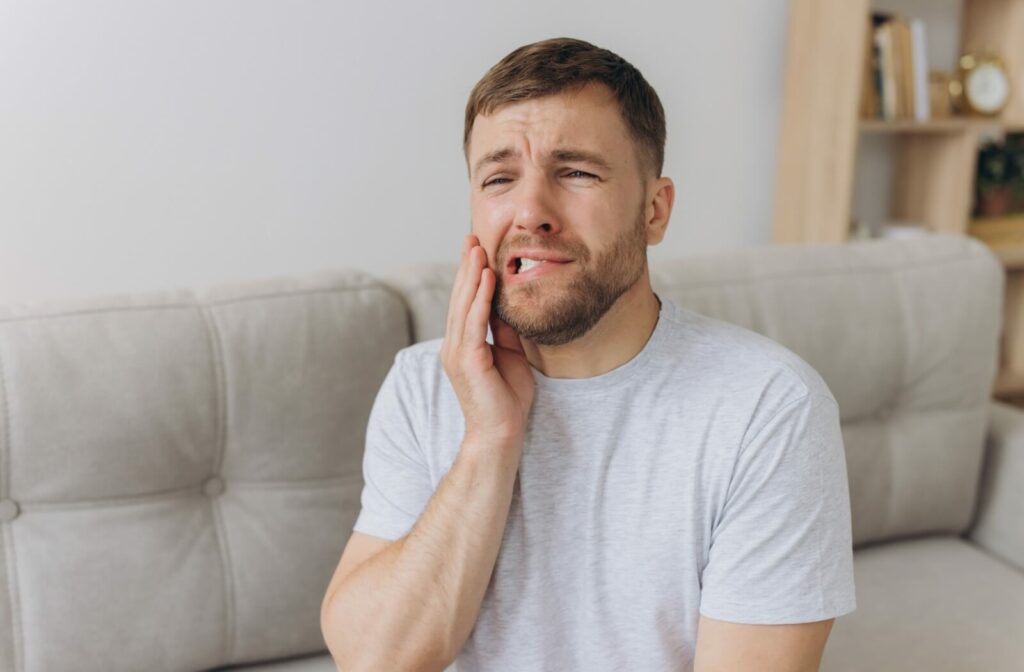 What-to-Eat-After-Tooth-Extraction-hero 3 | Belman Dental Centre A man clutches his jaw in pain pre-tooth extraction.