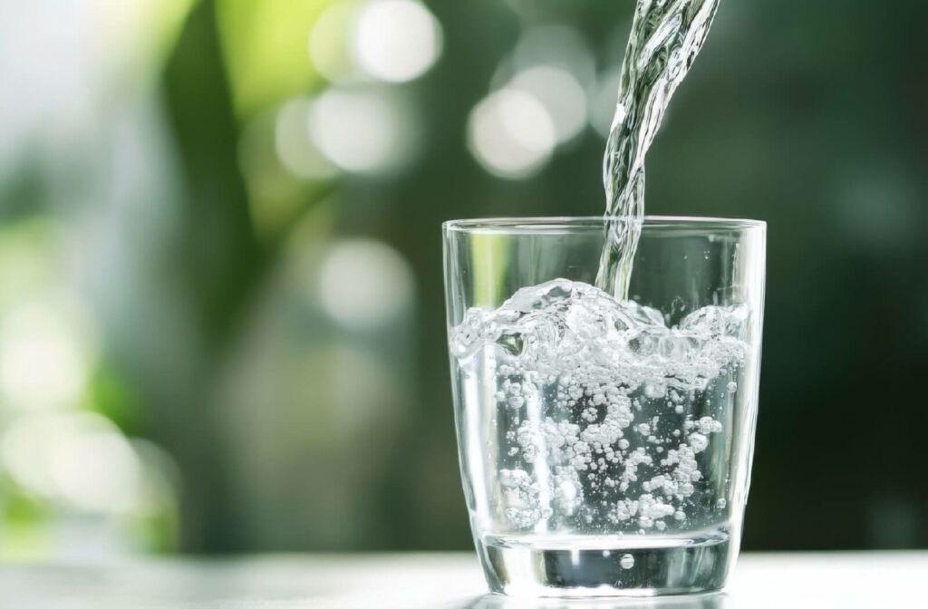 fluoride-in-torontos-tap-water-how-it-helps-your-dental-health-supporting (1) | Belman Dental Centre A close-up image of someone out-of-frame pouring water with fluoride into a clear glass.