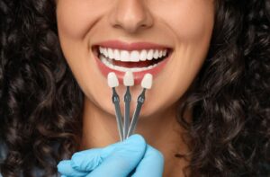 A woman comparing colours for her new dental veneers.