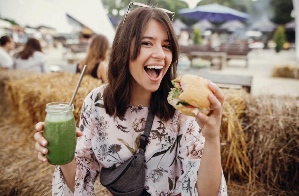 A person enjoying food and drink at a summer festival.