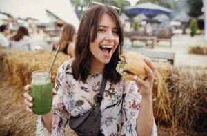 A person enjoying food and drink at a summer festival.