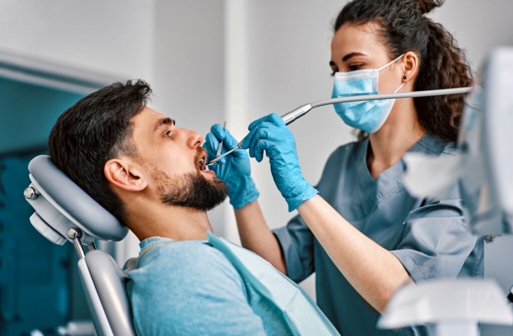 What Happens During a Dental Cleaning__supporting 1 | Belman Dental Centre A dental hygienist carefully removes tartar buildup from a patient's teeth during their dental cleaning.