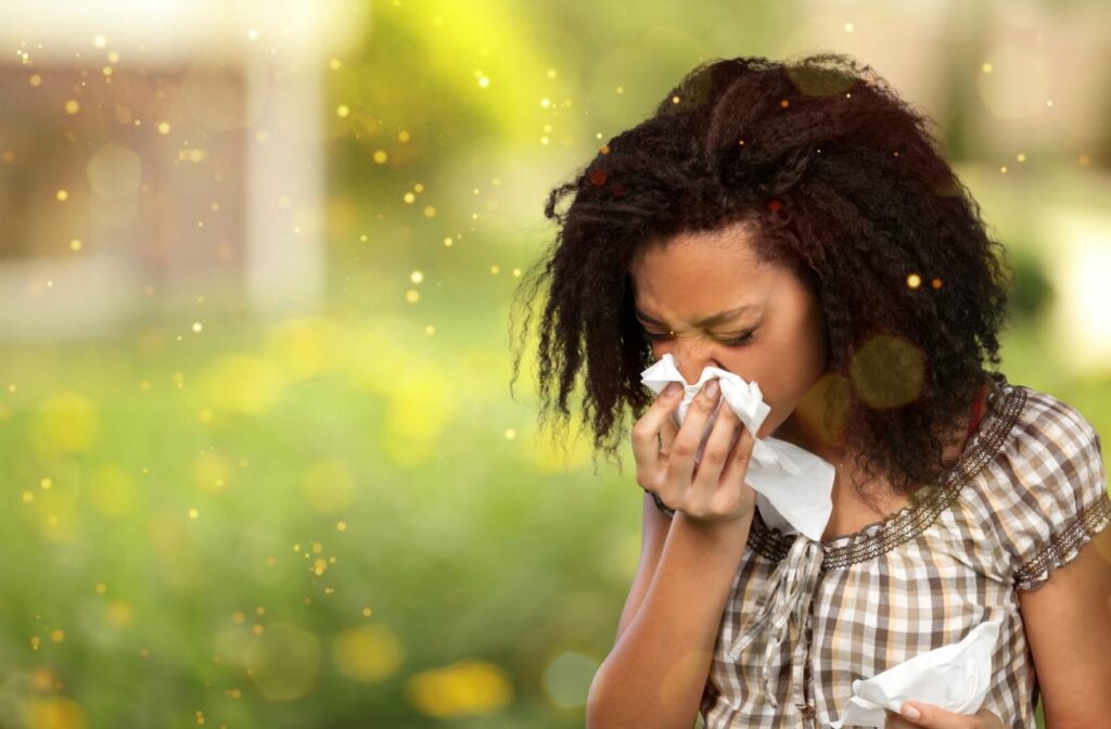 Person sneezing into a tissue due to allergies.